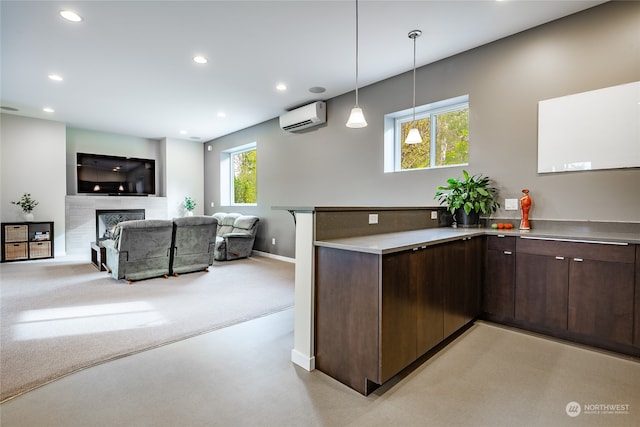 kitchen featuring a wall mounted AC, hanging light fixtures, dark brown cabinets, and plenty of natural light