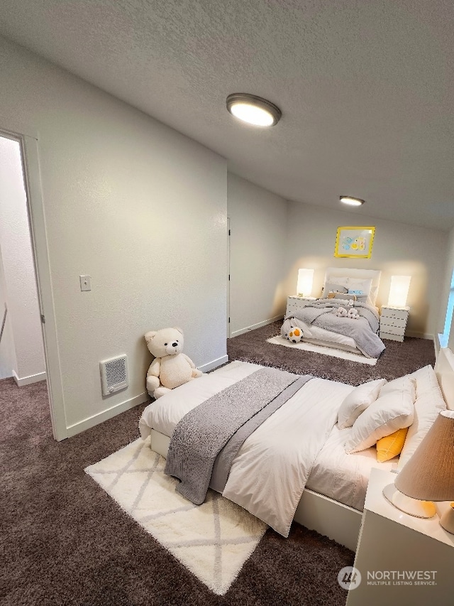 carpeted bedroom with a textured ceiling and heating unit