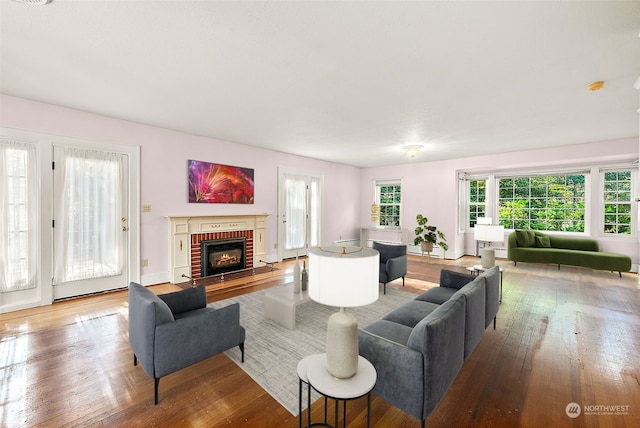 living room featuring hardwood / wood-style flooring and a brick fireplace