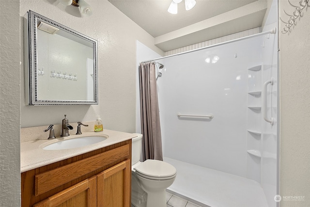 bathroom featuring toilet, a shower with curtain, vanity, and tile patterned floors