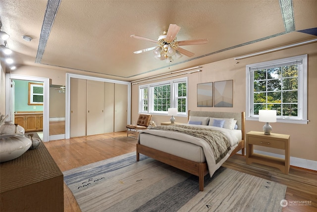 bedroom with multiple windows, a textured ceiling, and ceiling fan