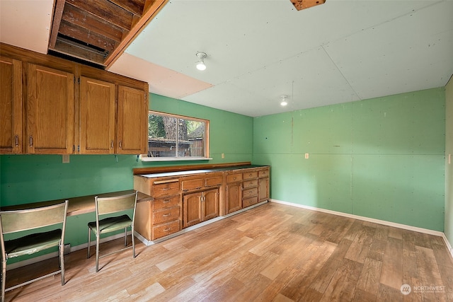 kitchen with built in desk and light wood-type flooring