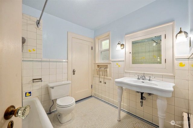 bathroom with toilet, tiled shower / bath combo, radiator, and tile walls