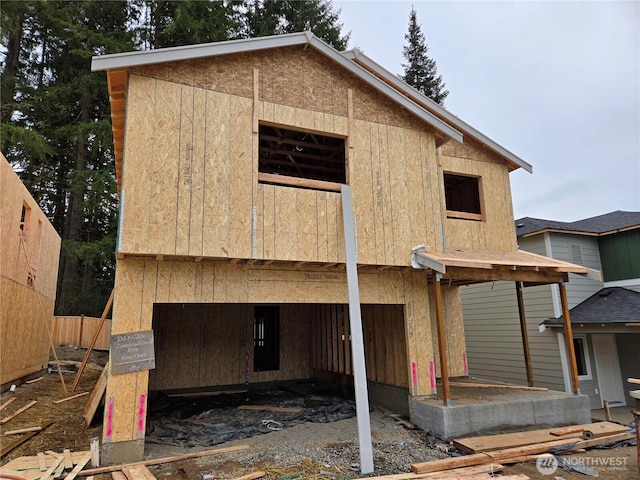 rear view of house featuring a garage and fence