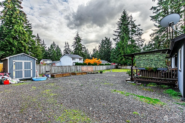 604 Nieland Loop SE, Rainier, WA 98576 - fenced backyard with a storage unit, an outdoor structure, and a wooden deck