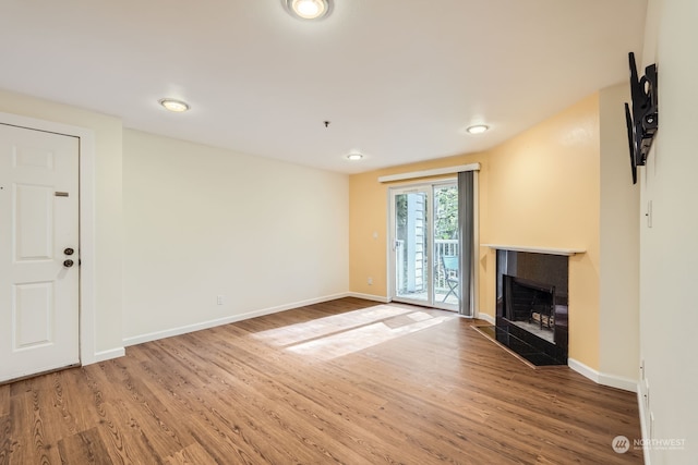 unfurnished living room with a fireplace and hardwood / wood-style floors