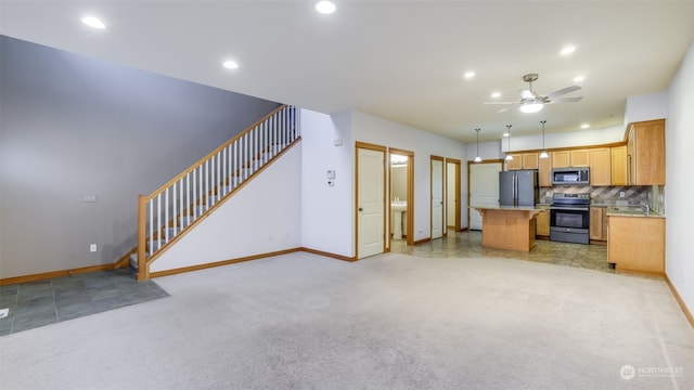 2733 Diamond St Unit D, Milton, WA 98354 - kitchen with appliances with stainless steel finishes, a kitchen island, backsplash, light carpet, and decorative light fixtures