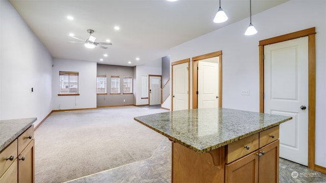 2733 Diamond St Unit D, Milton, WA 98354 - kitchen with light carpet, hanging light fixtures, light stone counters, ceiling fan, and a center island
