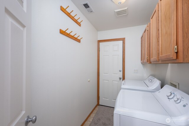 laundry room featuring light tile patterned flooring, cabinets, and separate washer and dryer