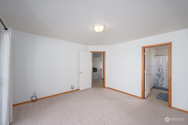 unfurnished bedroom with light colored carpet and ensuite bath