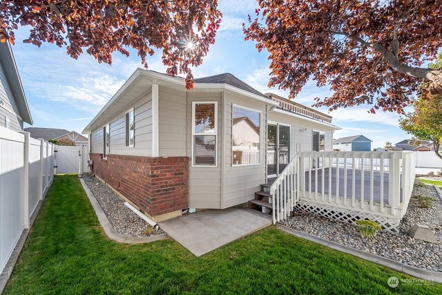 1300 W Marina Dr Unit 34, Moses Lake, WA 98837 - view of property exterior with brick siding, a wooden deck, and a gate
