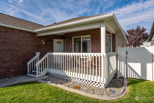 view of exterior entry with a yard