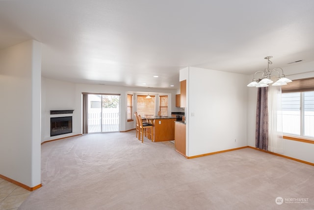 unfurnished living room with a chandelier and light carpet