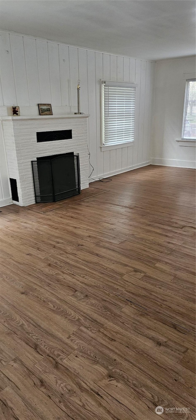 unfurnished living room with a fireplace and dark wood-type flooring