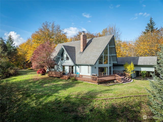 rear view of house featuring a deck and a lawn