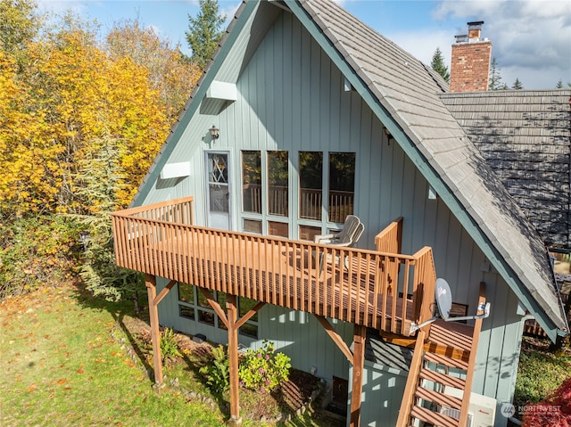 rear view of house with a wooden deck and a yard