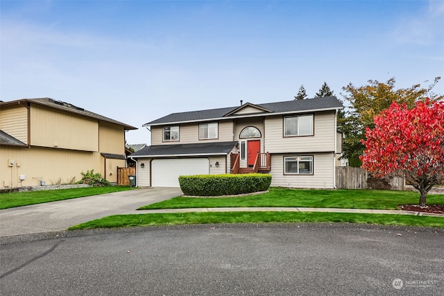 split foyer home featuring a front lawn and a garage