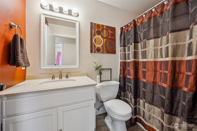 bathroom featuring vanity, toilet, and curtained shower