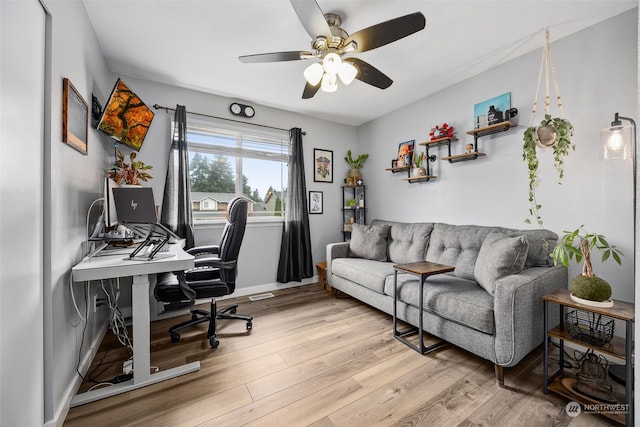 home office featuring ceiling fan and light hardwood / wood-style flooring