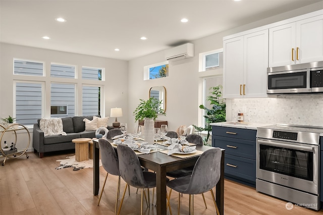 dining area with light wood-type flooring and an AC wall unit