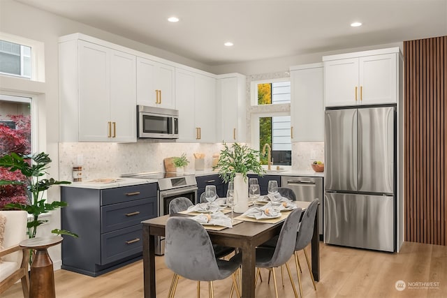 kitchen with white cabinetry, light hardwood / wood-style flooring, and stainless steel appliances