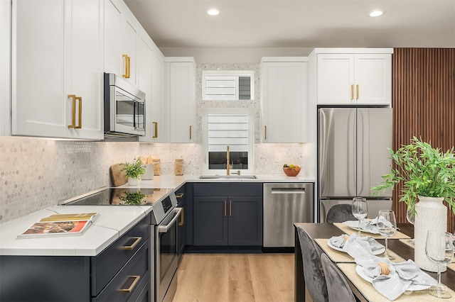 kitchen featuring light hardwood / wood-style flooring, stainless steel appliances, white cabinetry, and sink