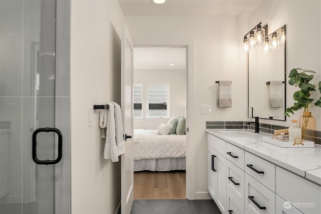 bathroom with hardwood / wood-style flooring, vanity, and a shower with door