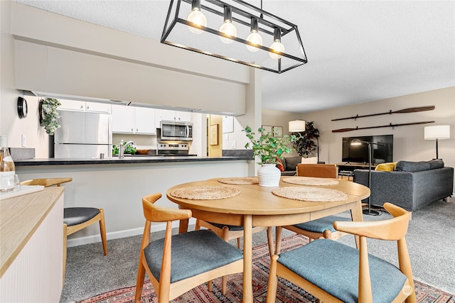 carpeted dining room featuring a textured ceiling