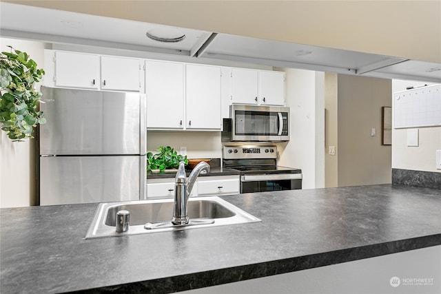 kitchen featuring appliances with stainless steel finishes, white cabinets, and sink