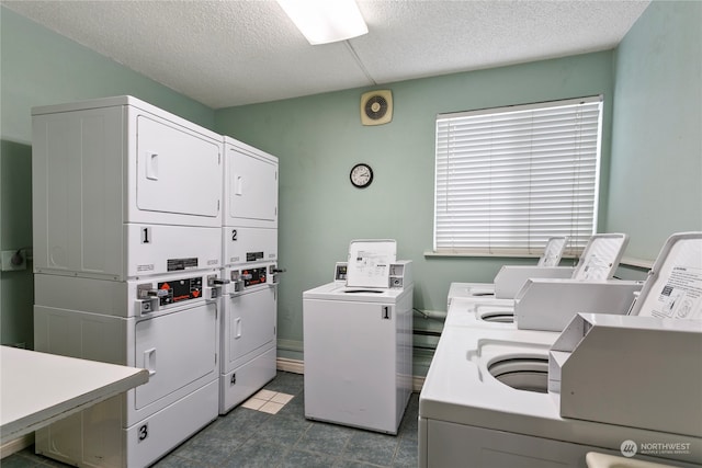 laundry area with stacked washer / dryer, washing machine and dryer, and a textured ceiling