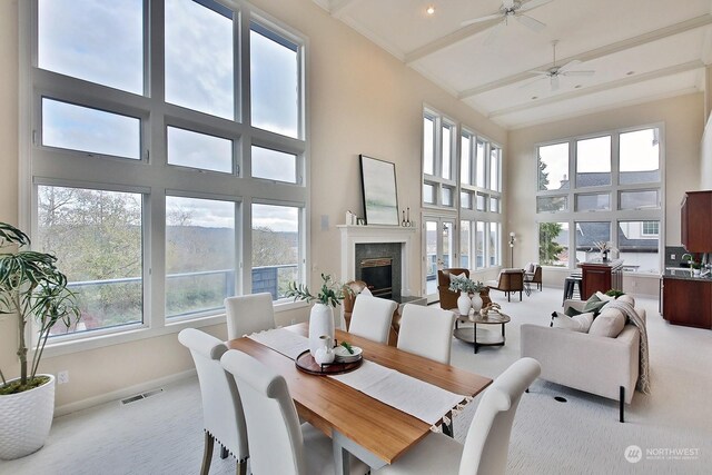 4962 Lilac Dr, Freeland, WA 98249 - dining room featuring light colored carpet, a towering ceiling, a high end fireplace, baseboards, and beam ceiling