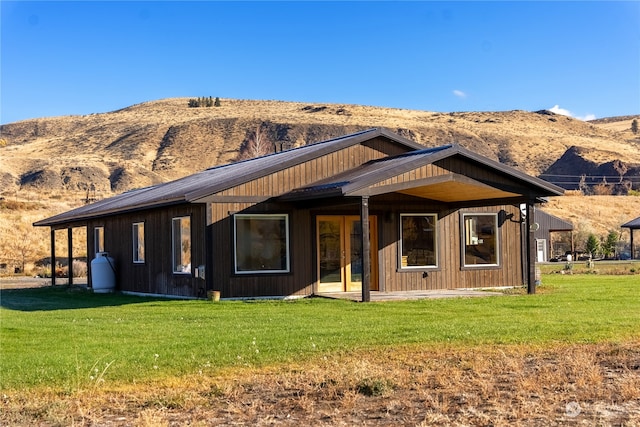 rear view of property with a yard and a mountain view