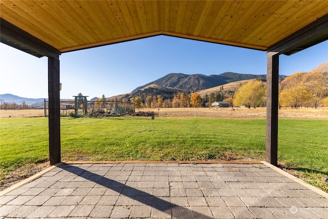 view of patio with a rural view and a mountain view