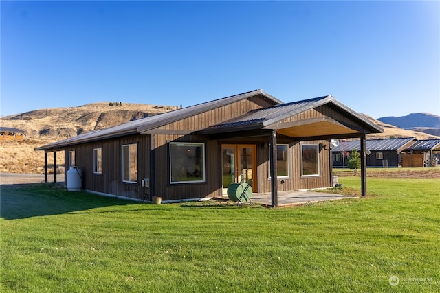 rear view of house featuring a yard and a mountain view