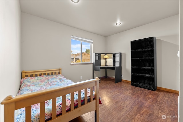 bedroom with dark hardwood / wood-style floors