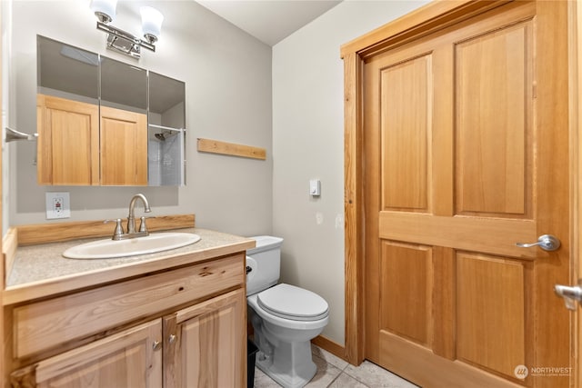 bathroom with walk in shower, vanity, toilet, and tile patterned flooring