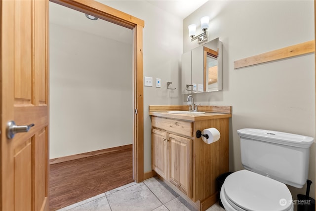 bathroom with vanity, wood-type flooring, and toilet