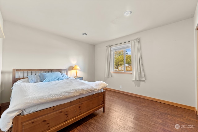 bedroom with dark hardwood / wood-style flooring