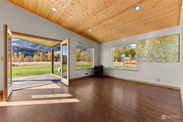 unfurnished living room featuring a mountain view, a wood stove, wooden ceiling, vaulted ceiling, and dark hardwood / wood-style flooring