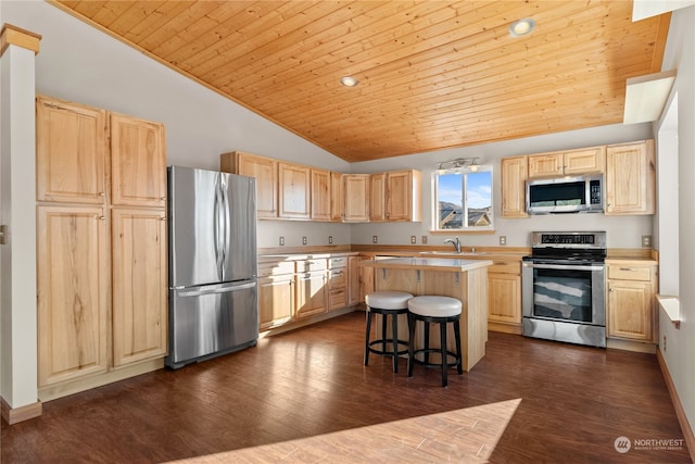 kitchen with dark hardwood / wood-style flooring, a center island, stainless steel appliances, and a breakfast bar area