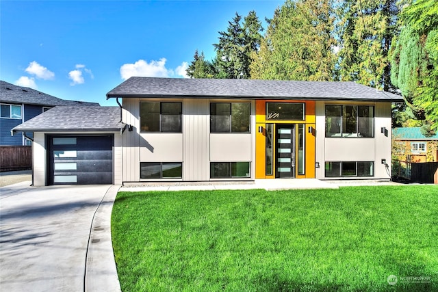 view of front of home with a front yard and a garage