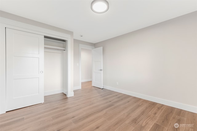 unfurnished bedroom featuring light hardwood / wood-style flooring and a closet