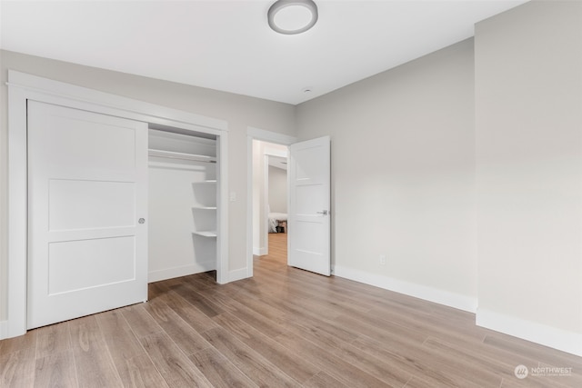 unfurnished bedroom with a closet and light wood-type flooring