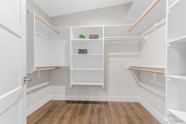 walk in closet featuring dark hardwood / wood-style flooring and lofted ceiling