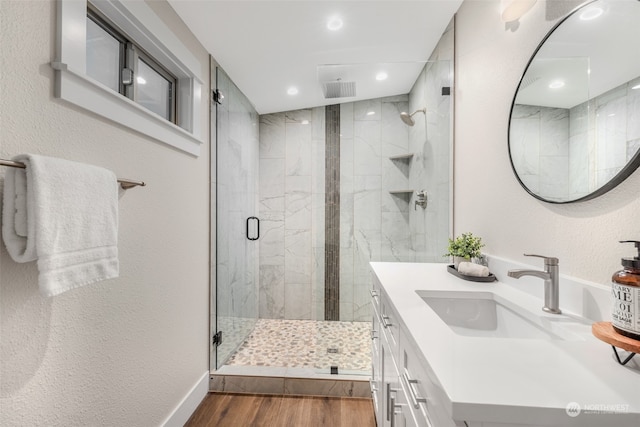 bathroom featuring hardwood / wood-style floors, vanity, and a shower with door