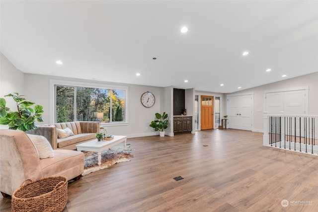 living room with hardwood / wood-style floors and vaulted ceiling