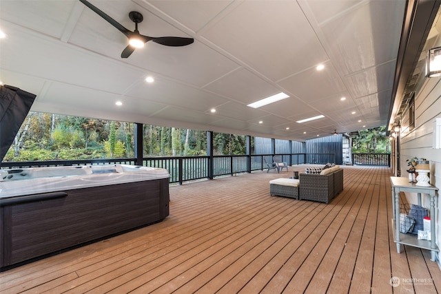 wooden terrace featuring a hot tub, outdoor lounge area, and ceiling fan