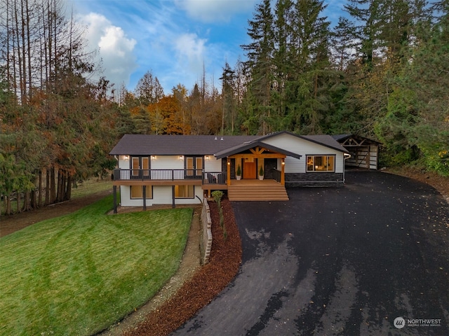 view of front of house featuring a wooden deck and a front lawn