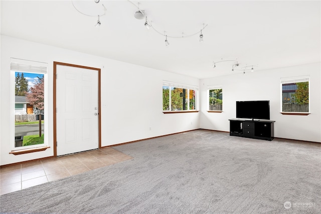 unfurnished living room featuring a healthy amount of sunlight and light colored carpet