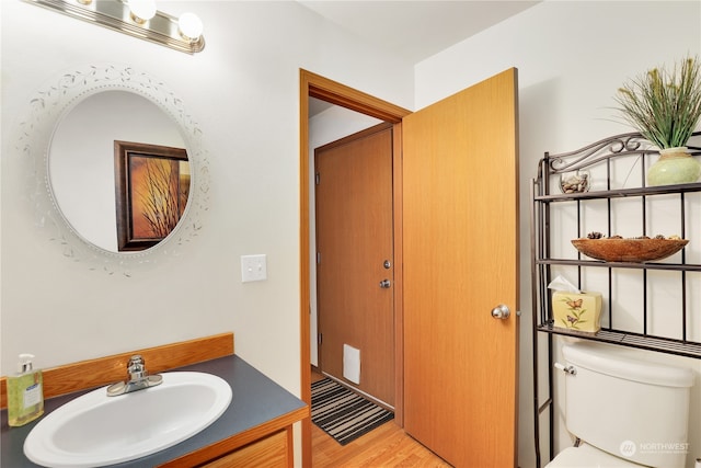 bathroom with vanity, toilet, and wood-type flooring